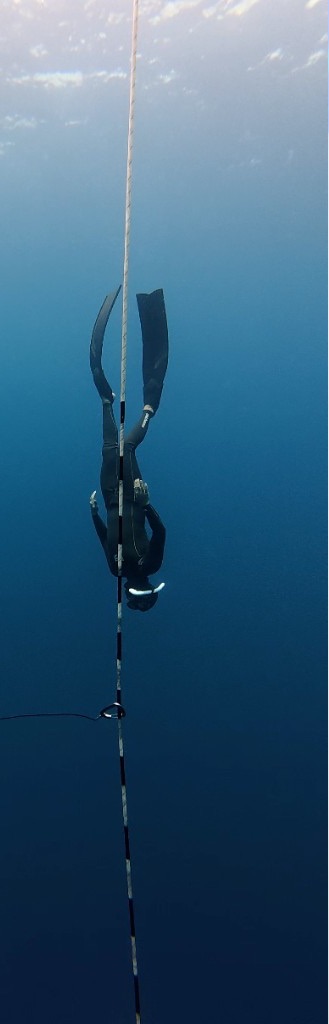 Julian descending the line in a black wetsuit